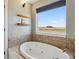 Bright bathroom featuring a large soaking tub next to a window showcasing beautiful outdoor views at 1212 N County Road 125, Bennett, CO 80102