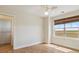 Bright bedroom featuring hardwood floors, a ceiling fan, and large windows with woven shades at 1212 N County Road 125, Bennett, CO 80102
