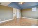 Bedroom with vaulted ceiling, laminate floors, olive-green walls and a doorway into the hall at 1212 N County Road 125, Bennett, CO 80102