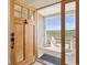 Inviting entryway with a wooden door that looks out on a covered porch and beautiful views at 1212 N County Road 125, Bennett, CO 80102