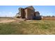 View of house with dirt driveway and lawn, partial patio visible at 1212 N County Road 125, Bennett, CO 80102