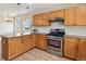 Modern kitchen with wooden cabinets, stainless steel appliances, and a center island with granite countertops at 1212 N County Road 125, Bennett, CO 80102