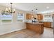 Bright kitchen with custom wooden cabinets, an island, and large windows overlooking a scenic view at 1212 N County Road 125, Bennett, CO 80102