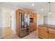 Modern kitchen with stainless steel fridge, wooden cabinets, and ample counter space at 1212 N County Road 125, Bennett, CO 80102