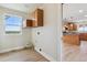Convenient laundry room with storage cabinets, washer/dryer hookups, and an exterior view at 1212 N County Road 125, Bennett, CO 80102