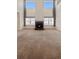 Spacious living room featuring soaring ceilings, a cozy fireplace, neutral carpet, and multiple windows at 1212 N County Road 125, Bennett, CO 80102