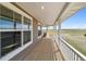 Wide porch with wood flooring, white railings, and views of surrounding fields at 1212 N County Road 125, Bennett, CO 80102