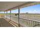 Porch featuring wood flooring, white railings and posts, with expansive view of field at 1212 N County Road 125, Bennett, CO 80102