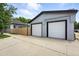 Detached two car garage with white garage doors and a long driveway at 4059 Quivas St, Denver, CO 80211