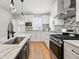 Bright kitchen featuring stainless steel appliances, a large sink, hardwood floors and light countertops at 4059 Quivas St, Denver, CO 80211
