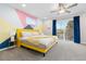 Bright bedroom features a unique geometric accent wall, ceiling fan and a sliding glass door to the outdoor patio at 8506 Eaton St, Arvada, CO 80003