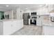 Modern kitchen featuring stainless steel appliances, white cabinetry, and stylish tile flooring at 8506 Eaton St, Arvada, CO 80003