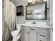 Bathroom with gray vanity, mirror, and dark wall cabinet, plus patterned shower curtain at 9615 W Chatfield Ave # C, Littleton, CO 80128