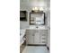 Bathroom with gray vanity, modern mirror, toilet, and dark wall cabinet above at 9615 W Chatfield Ave # C, Littleton, CO 80128