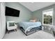 Cozy bedroom features a lounge chair, television, bright windows and a blue comforter at 9615 W Chatfield Ave # C, Littleton, CO 80128