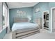 This spacious bedroom features a light gray wood bed frame and bright blue walls at 9615 W Chatfield Ave # C, Littleton, CO 80128