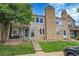 Charming townhouse featuring stone accents, lush lawn, and inviting front porch at 9615 W Chatfield Ave # C, Littleton, CO 80128