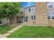Charming townhouse featuring stone accents, lush lawn, and inviting front porch at 9615 W Chatfield Ave # C, Littleton, CO 80128