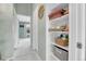 Hallway with view into an adjacent bedroom, and an open storage closet with towels at 9615 W Chatfield Ave # C, Littleton, CO 80128