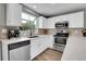 Bright kitchen features white cabinets, stainless steel appliances, and a large window at 9615 W Chatfield Ave # C, Littleton, CO 80128