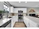 Well-lit kitchen with quartz countertops, stainless steel appliances, and wood-style flooring at 9615 W Chatfield Ave # C, Littleton, CO 80128