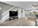 Open-concept living area with wood floors, adjacent to a white staircase and kitchen at 9615 W Chatfield Ave # C, Littleton, CO 80128