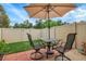 The private backyard patio includes a dining set with seating, an umbrella and privacy fence at 9615 W Chatfield Ave # C, Littleton, CO 80128