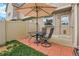 The backyard patio features brick pavers, seating, a table, and sun umbrella at 9615 W Chatfield Ave # C, Littleton, CO 80128