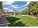 Large backyard with a well-manicured lawn, stone area, pergola, and shed, ideal for outdoor living at 4500 Zephyr St, Wheat Ridge, CO 80033