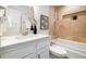 Bathroom showcasing tiled walls, a shower-tub combo, and a stylish vanity with a white countertop at 4500 Zephyr St, Wheat Ridge, CO 80033