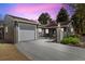 Charming home with gray brick, well-manicured landscaping, and a driveway leading to an attached garage at 4500 Zephyr St, Wheat Ridge, CO 80033