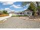 Charming front yard, features gravel, brick-lined flowerbed, lush greenery and garage at 4500 Zephyr St, Wheat Ridge, CO 80033