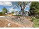 Spacious front yard has shade trees, brick-lined flowerbed, and shrubs at 4500 Zephyr St, Wheat Ridge, CO 80033