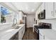 Bright kitchen features stainless steel appliances, white cabinetry, granite countertops, and a large window at 4500 Zephyr St, Wheat Ridge, CO 80033