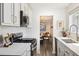 Charming kitchen featuring white cabinets and countertops, a modern stovetop, and an open view to the dining room at 4500 Zephyr St, Wheat Ridge, CO 80033