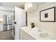 A convenient laundry room with a stacked washer and dryer, overhead cabinets, and a folding area at 4500 Zephyr St, Wheat Ridge, CO 80033