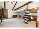 Spacious living room with brick fireplace, exposed beams, loft space, and spiral staircase at 4500 Zephyr St, Wheat Ridge, CO 80033