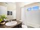 Cozy bathroom featuring a vanity with a white sink, a window, and a shower with white tile surround at 2516 Mountain Sky Dr, Castle Rock, CO 80104