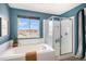 Well-lit bathroom featuring a garden tub, glass enclosed shower, and a window with neighborhood views at 2516 Mountain Sky Dr, Castle Rock, CO 80104