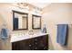 Bathroom with double vanity, framed mirrors, and modern lighting fixtures at 2516 Mountain Sky Dr, Castle Rock, CO 80104