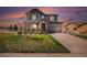 Two-story home with well-kept lawn, brick accents, covered porch, and attached garage at 2516 Mountain Sky Dr, Castle Rock, CO 80104