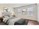 Relaxing bedroom featuring a king-size bed, stylish decor, and plenty of natural light from two windows at 1639 S Ivory Cir # C, Aurora, CO 80017