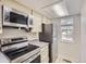 Modern kitchen with stainless steel appliances, bright lighting, stone countertops, and a window view at 1639 S Ivory Cir # C, Aurora, CO 80017