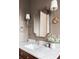 Bathroom featuring a marble countertop, decorative mirror, sconces, and modern sink fixtures at 1680 S Humboldt St, Denver, CO 80210