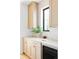 Close-up of a kitchen counter with neutral cabinets, black window frame and stylish decor at 1680 S Humboldt St, Denver, CO 80210