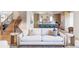 Bright, modern living room featuring a white sofa, open staircase, and an airy view into the kitchen at 1680 S Humboldt St, Denver, CO 80210