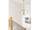 Bright stairwell featuring a modern gold chandelier and oak railings with black iron balusters at 1680 S Humboldt St, Denver, CO 80210