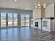 Open living room with hardwood floors, stone fireplace, and large windows with natural light at 17569 Cerberus Ct, Monument, CO 80132