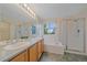 Bright bathroom with double sinks, soaking tub, and glass-enclosed shower at 9869 Burberry Way, Highlands Ranch, CO 80129