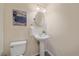 Charming powder room featuring pedestal sink, oval mirror, and modern artwork at 9869 Burberry Way, Highlands Ranch, CO 80129